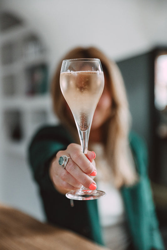 A woman holding a glass of Prosecco